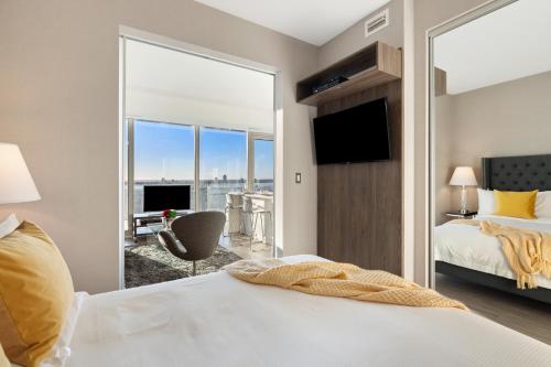 sypialnia z łóżkiem i dużym oknem w obiekcie SOHO Residences Champagne w mieście Ottawa