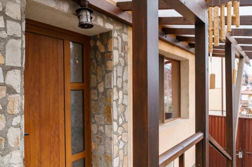 uma casa com uma porta de madeira e uma janela em Фън Шуй Къща за гости 88 em Dobrinishte