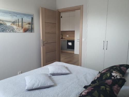 Un dormitorio con una cama con dos almohadas encima. en Apartament Słoneczny 28 Słoneczna Dolina, en Jastrzębia Góra