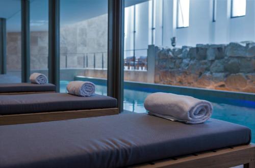 two beds with towels on them next to a swimming pool at The Phoenicia Malta in Valletta