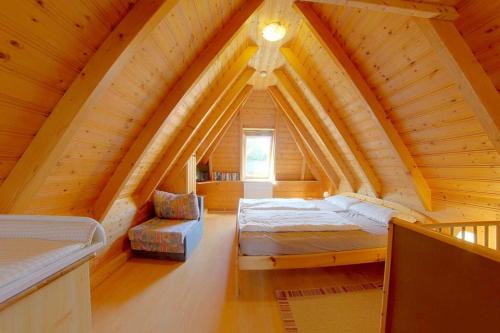 - une chambre avec un lit dans un grenier en bois dans l'établissement Strandvogt 2 TP22, à Dorum Neufeld