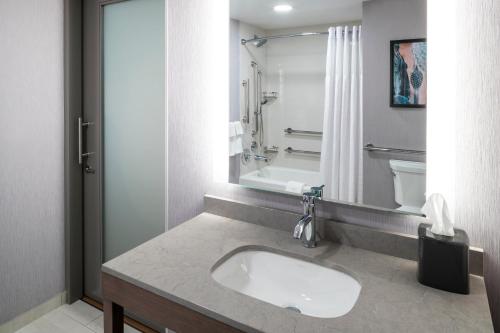 a bathroom with a sink and a toilet and a mirror at Hyatt House Tempe Phoenix University in Tempe
