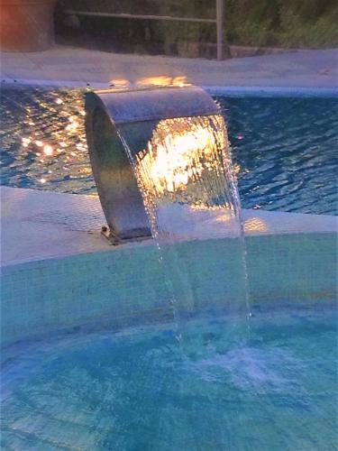 a water fountain in front of a swimming pool at Hotel Myage in Ischia