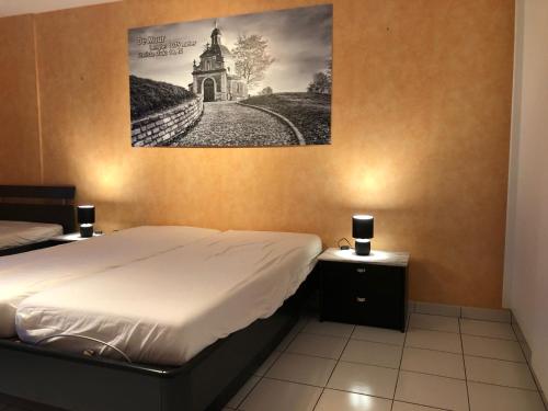 a bedroom with a bed and a picture on the wall at Vakantiewoning De Kassei Geraardsbergen max 12personen in Geraardsbergen
