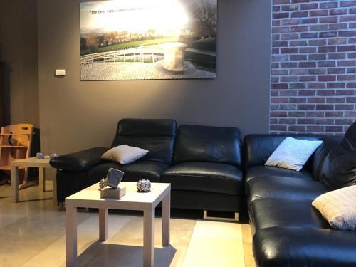 a living room with a couch and a table at Vakantiewoning De Kassei Geraardsbergen max 12personen in Geraardsbergen