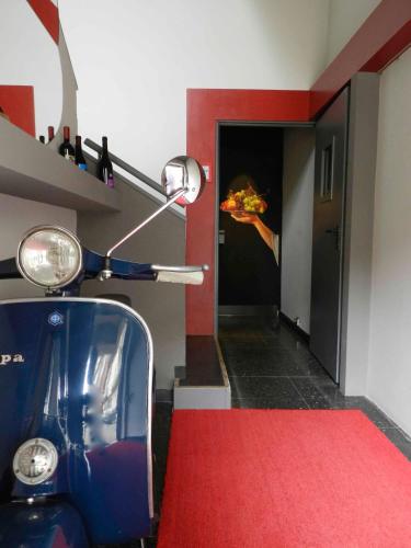 a scooter in a room with a person holding a pizza at Hotel Italia in Stradella