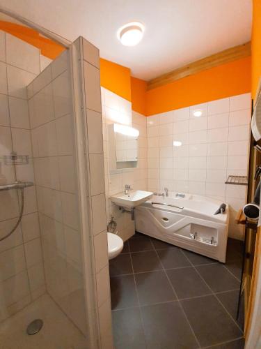 a bathroom with a tub and a sink and a toilet at Walensee House & Apartments in Unterterzen