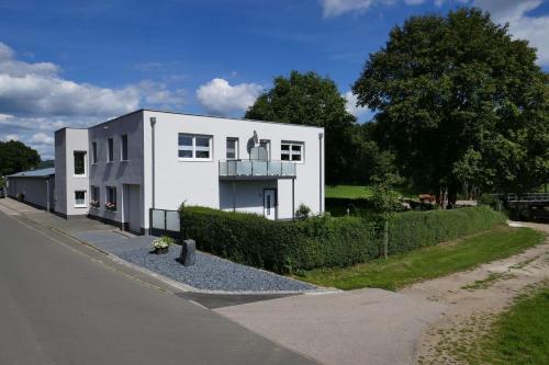 a white house on the side of a street at Landferien Eifel in Pittenbach