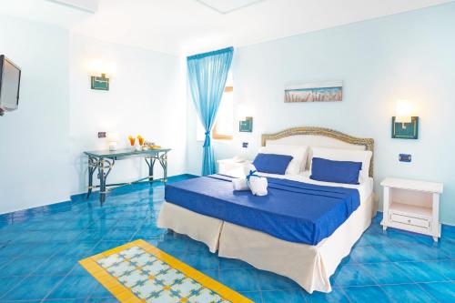 Dormitorio azul con cama y mesa en Hotel Myage, en Isquia