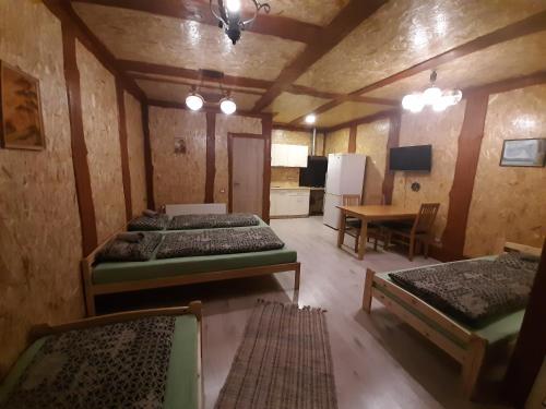 a room with three beds and a table and a kitchen at Atpūtas vieta Buki in Ventspils