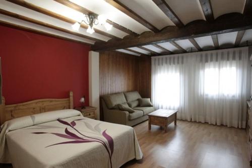 1 dormitorio con cama y sofá en Casona Santa Coloma, en Matute de la Sierra