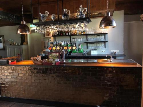 a bar with a brick counter with glasses at Herberg Oud Holset in Lemiers