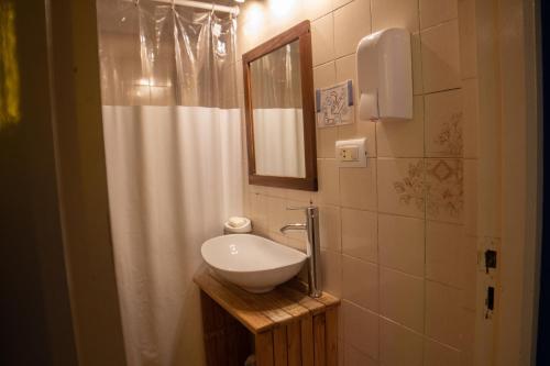 a bathroom with a sink and a shower curtain at Pinamar Hostel Casa de Verano in Pinamar