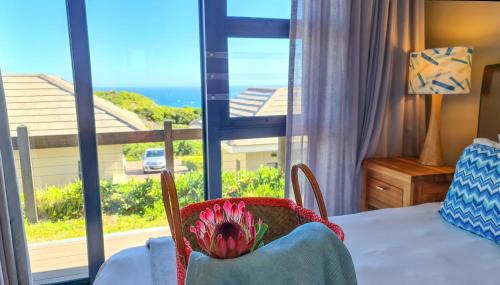 a bedroom with a bed and a view of the ocean at Brenton Haven Beachfront Resort in Knysna