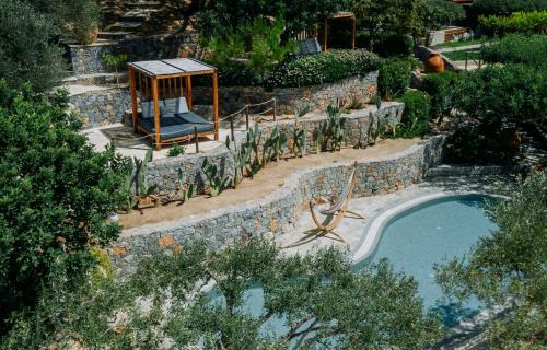 a pool in a garden with a gazebo at Paralos Irini Mare in Agia Galini
