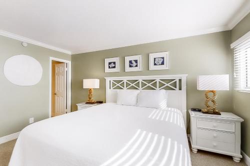 a bedroom with a white bed and two night stands at Beach House IV in Destin