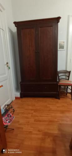 a dark wooden cabinet in a room with a wooden floor at Casa Cristina in Siracusa