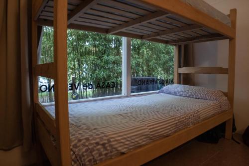 una litera en una habitación con ventana en Pinamar Hostel Casa de Verano, en Pinamar