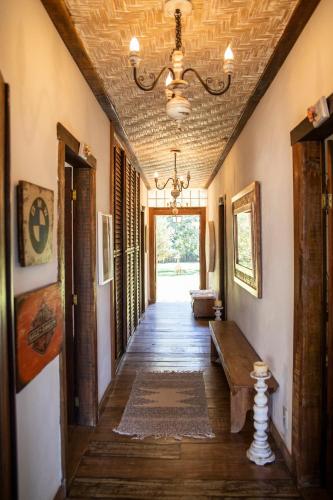 a hallway of a house with a chandelier at Pouso do Bichinho 1 in Bichinho