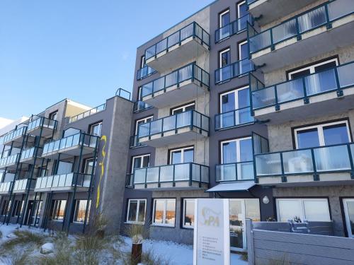 an apartment building with a sign in front of it at Beachhotel Cuxhaven in Cuxhaven