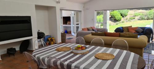 ein Wohnzimmer mit einem Tisch und einem Sofa in der Unterkunft Southern Cross Beach House in Groot Brak Rivier