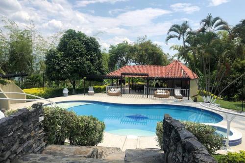 een zwembad met een prieel en een huis bij Casa con piscina y zona de BBQ en la Mesa Cundinamarca in Anapoima