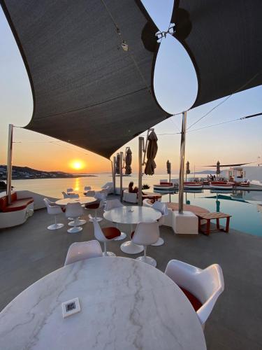 a group of tables and chairs and a pool at Absolute Mykonos Suites & More in Mikonos