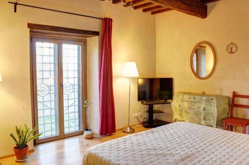 a bedroom with a large bed and a television at Il Fienile in Figline Valdarno
