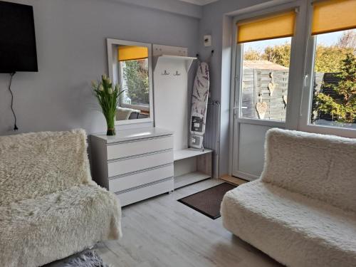 uma sala de estar com duas cadeiras e uma cómoda e um espelho em Pokoje Gościnne Biura Turystycznego KRIS em Kudowa-Zdrój