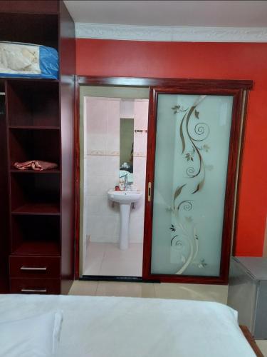 a bedroom with a bathroom with a sink and a mirror at SMART INN GUEST HOUSE in Jwaneng