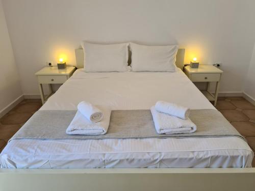 a bedroom with a bed with two towels on it at Kouros Village in Antiparos Town