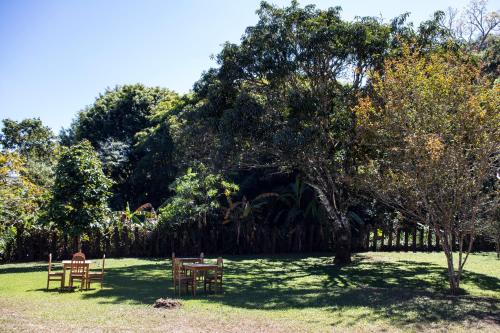 a park with tables and chairs in the grass at Pouso do Bichinho 1 in Bichinho