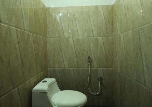 a bathroom with a toilet and a shower at STAYMAKER Regal Residency in Gulbarga