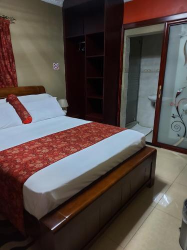 a bedroom with a large bed and a bathroom at SMART INN GUEST HOUSE in Jwaneng