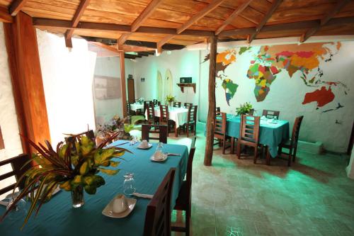 um restaurante com mesas e cadeiras e um mural mundial na parede em Hotel LA GRAN TORTUGA - ᯤ STARLINK em Puerto Villamil