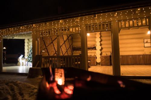 a fireplace in front of a deck with christmas lights at Adele in Mizhhirʼʼya