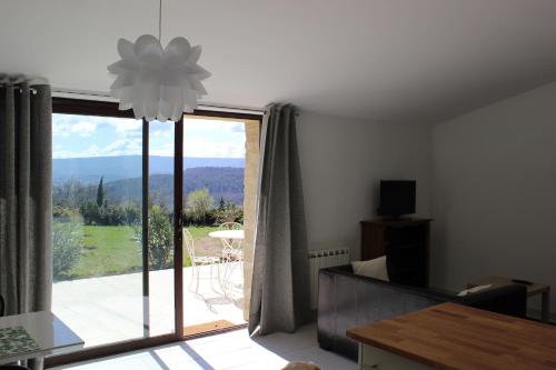 a living room with a large sliding glass door at Gîte Les Rapières in Gordes