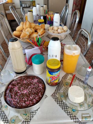 una mesa cubierta con mucha comida y bebida en Hospedaria Piramide Por Do Sol, en São Thomé das Letras