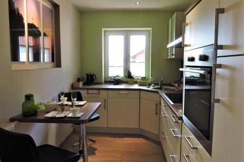 una cucina con un piccolo tavolo e una cucina con frigorifero di Apartment Am Anker a Uchte