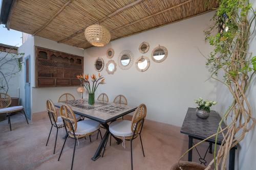 una sala da pranzo con tavolo e sedie di Riad Le J a Marrakech