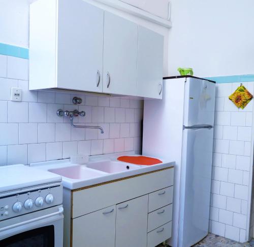una cucina con armadietti bianchi e frigorifero bianco di La casa di Bellippa a Tricase