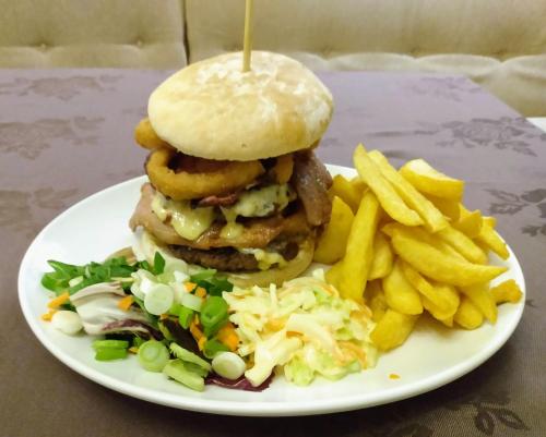 a white plate with a hamburger and french fries at Marine Hotel in Buckie