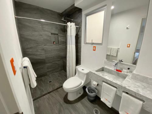 a bathroom with a toilet and a shower and a sink at Hotel Star Express Puebla - Central CAPU in Puebla