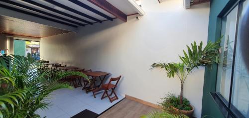 un patio con mesas, sillas y plantas en Pousada Mirai -Centro- en Arraial do Cabo