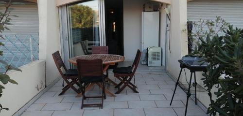 un patio avec une table et des chaises sur un balcon dans l'établissement Le Bora-Bora, à Marseillan