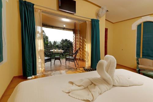 a bedroom with a bed with a swan made out of towels at Vista Del Lago in Ambalavayal