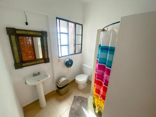 a bathroom with a sink and a toilet and a mirror at Hostel Inn in San Miguel de Allende