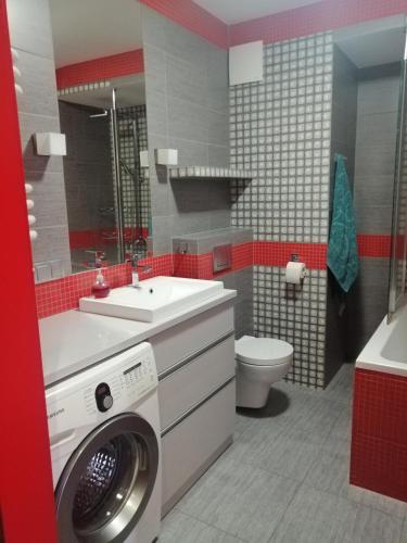 a bathroom with a washing machine and a sink at Kawalerka wielki kack in Gdynia