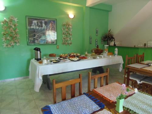 ein Esszimmer mit einem weißen Tisch in einem grünen Raum in der Unterkunft Pousada Vista Verde in Cunha