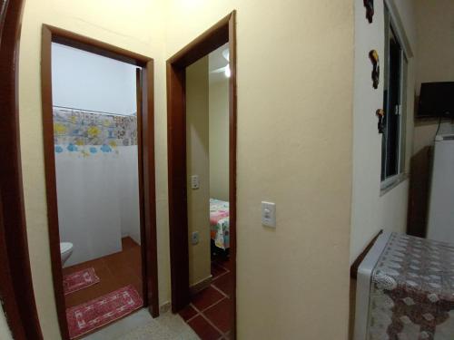 a hallway with a door and a mirror in a room at FLATS Beira Mar Prainha Barra de Sao Joao - Rio das Ostras in Barra de São João